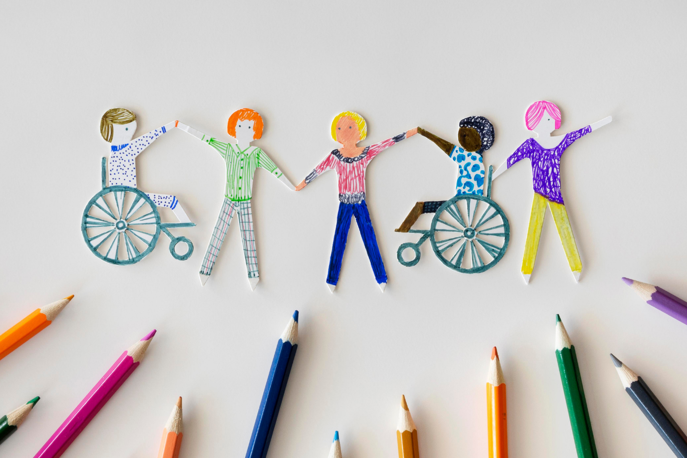 Ausgeschnittene Zeichnungen von verschiedenen Personen die Hände halten, da drunter zwei Personen im Rollstuhl.